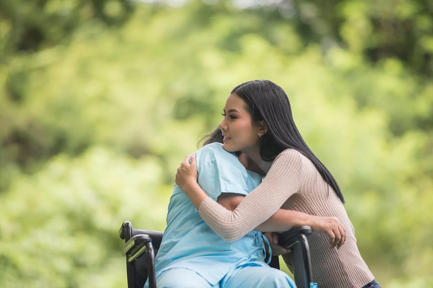 Caregiver hugging a senior in a wheelchair - Care to Stay Home locations