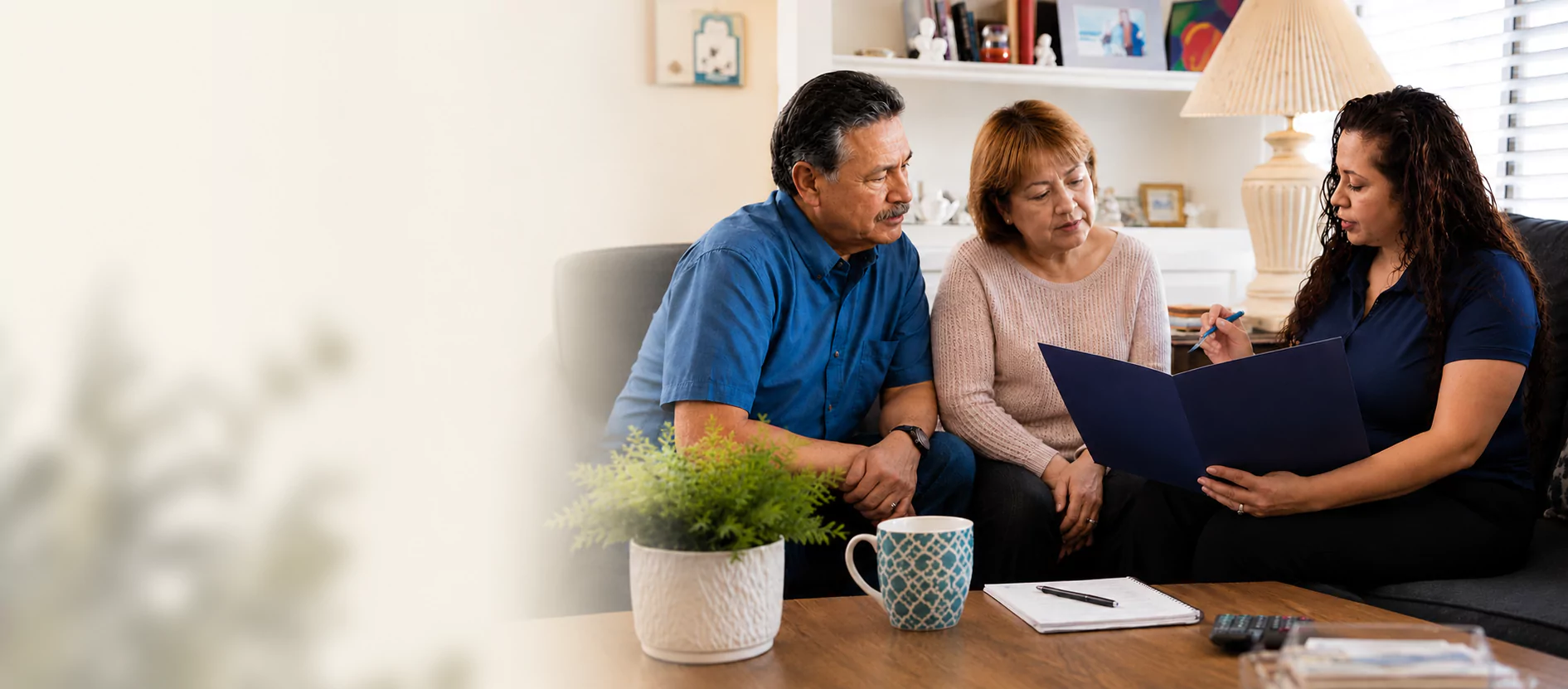 Advisor discussing documents with an elderly couple at home